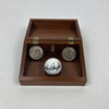 Celebrating Johnny Rutherford's 1974 & 1976 Indianapolis 500 victories is a signed Titleist golf ball and two Eisenhower dollar coins displayed in a wooden hinged box.